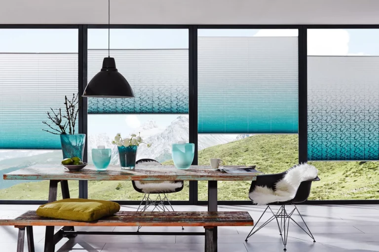 Das Bild zeigt ein Esszimmer mit einer großen Fensterfront. Die Plissees von Suntec aus Coesfeld bieten Ihnen optimalen Sonnenschutz und sorgen für Privatsphäre.